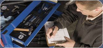 A man taking notes over a tools box